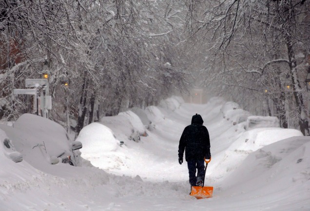 A man drags a shovel up Beacon Hill during a severe winter snow storm in Boston